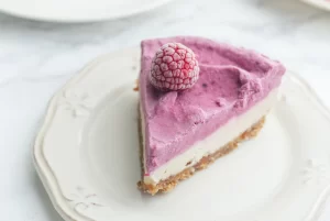 a slice of the no-bake rasberry cheesecake on a simple porcelean plate